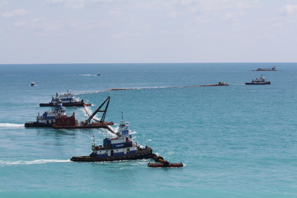 barges pushing a pipeline for beach renourishment