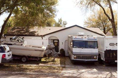 home with several trailers and boats in front yard