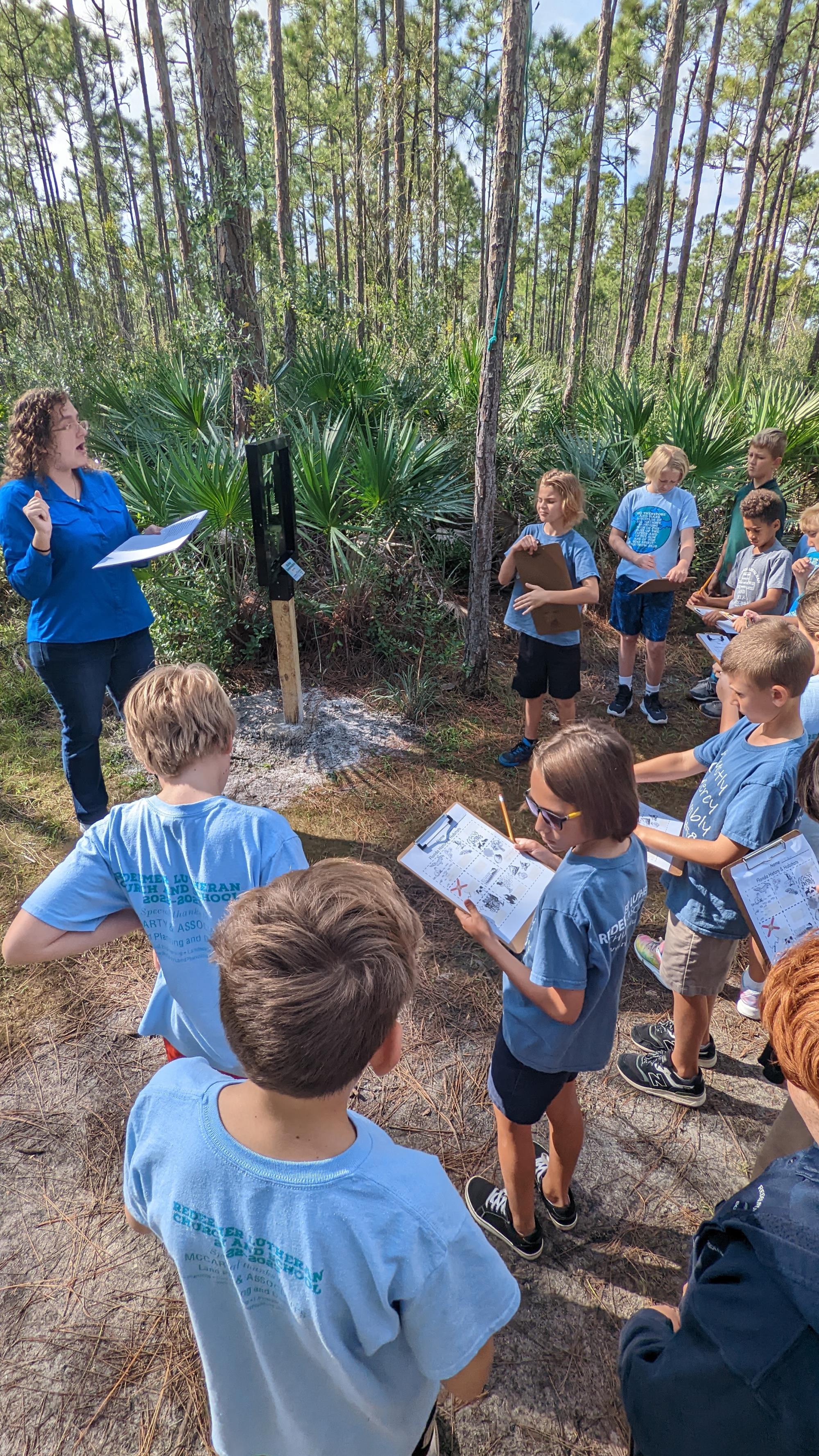 students with clipboards in the forest