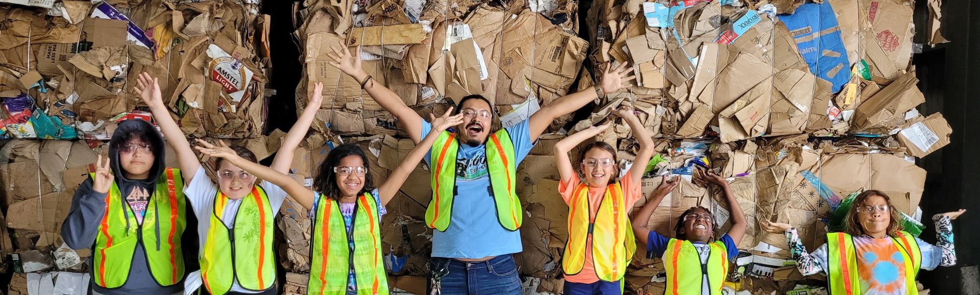 Children standing with recycled cardboard