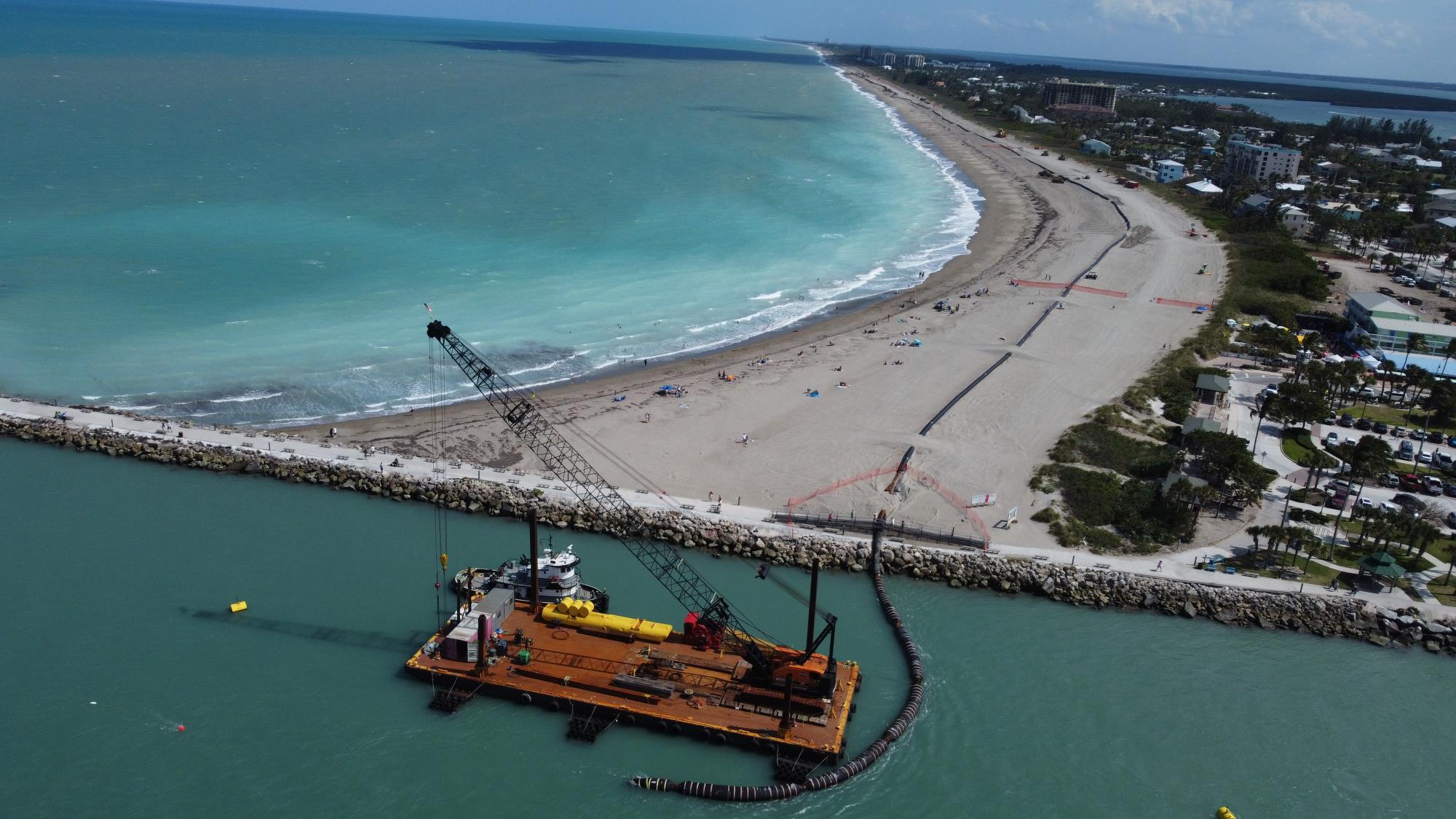 Beach shore aerial with barge on water